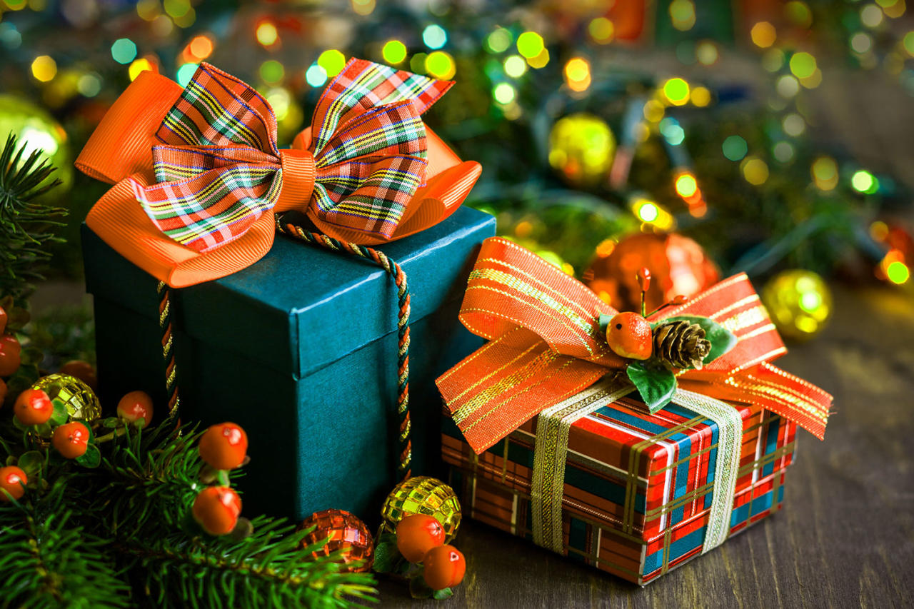 A brown teddy bear surrounded by colorful ornaments, rather than Christmas ornaments. 